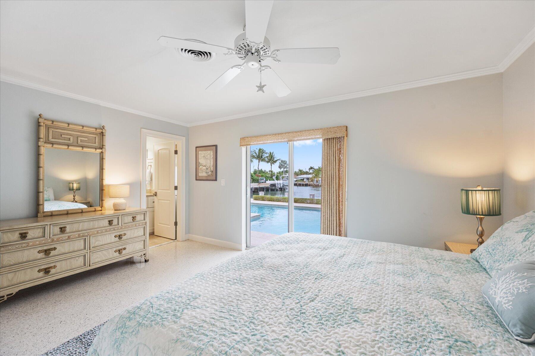 1180 Singer Drive Singer Island, FL 33404 - Photo 12 of 24 a bedroom with a bed and a chandelier