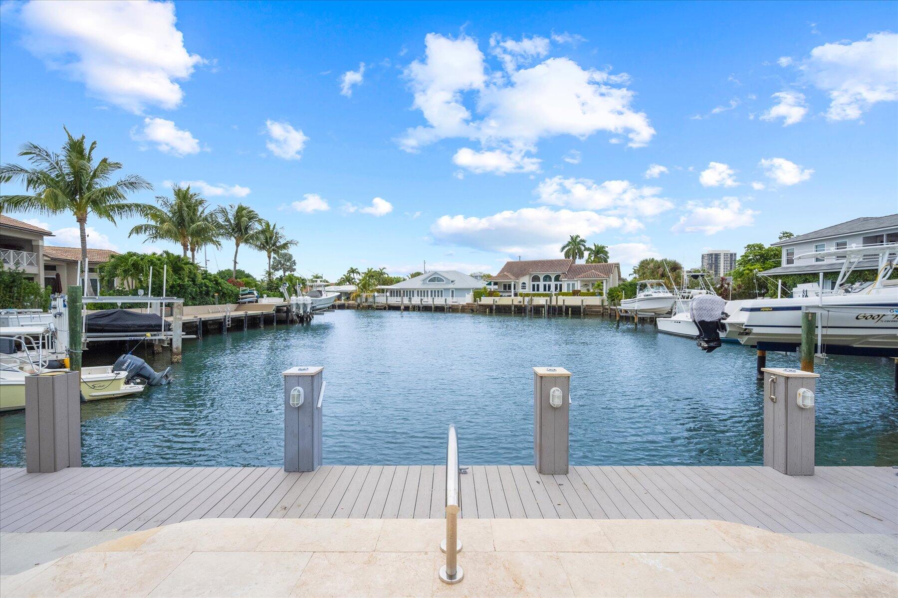 1180 Singer Drive Singer Island, FL 33404 - Photo 2 of 24 a street view with boat and palm trees
