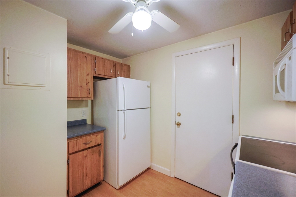 16 Erick Road, Unit 34 Mansfield, MA 02048 - Photo 6 of 14 a utility room with refrigerator and cabinet
