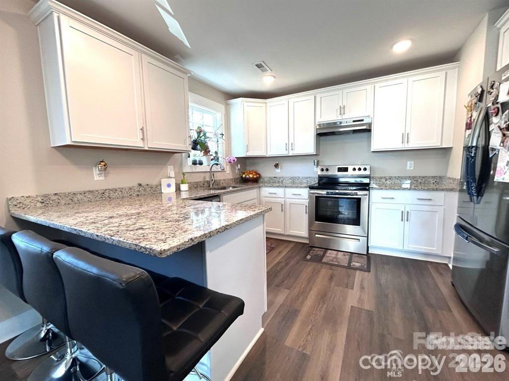 606 East Carpenter Street Dallas, NC 28034 - Photo 3 of 9 a kitchen with stainless steel appliances granite countertop a stove a sink dishwasher and a refrigerator with white cabinets