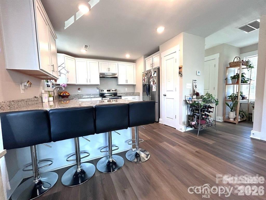 606 East Carpenter Street Dallas, NC 28034 - Photo 4 of 9 a kitchen with stainless steel appliances wooden floors dining table and chairs