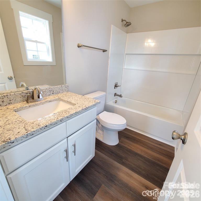 606 East Carpenter Street Dallas, NC 28034 - Photo 7 of 9 a bathroom with a granite countertop sink toilet mirror vanity and bathtub