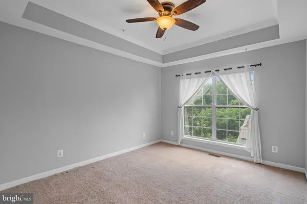 an empty room with a ceiling fan and a window