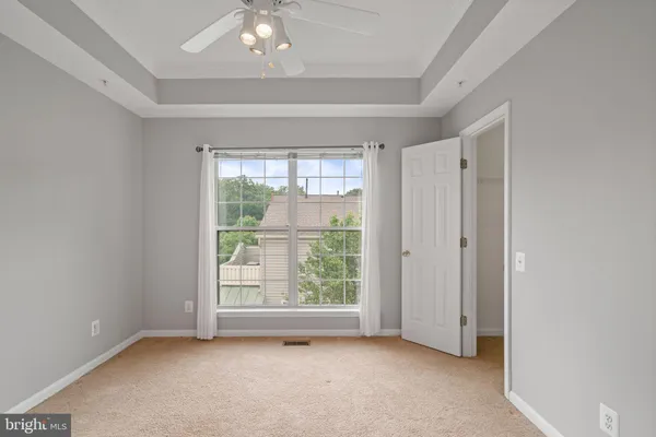 a view of an empty room with chandelier fan and closet