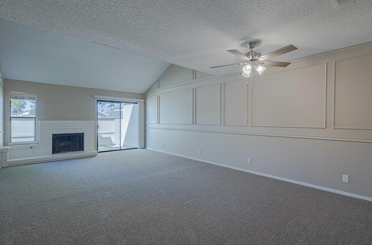 1840 Cherokee Drive, Unit 1 Salinas, CA 93906 - Photo 4 of 32 an empty room with chandelier fan and fireplace