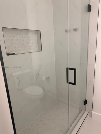 a bathroom with a toilet and a shower