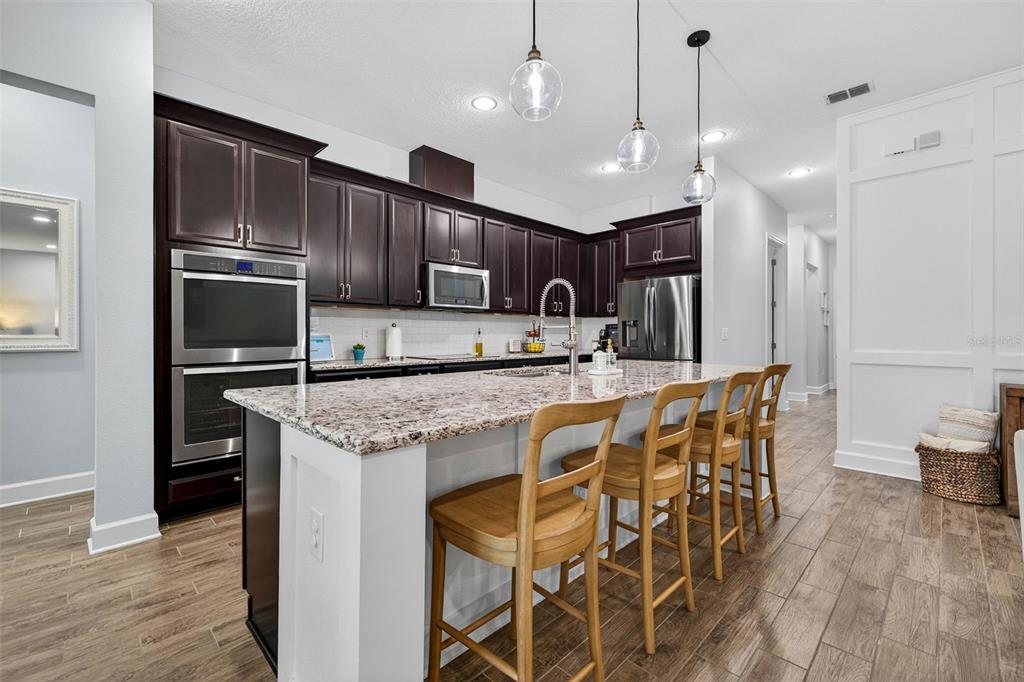 10522 Cardera Drive Riverview, FL 33578 - Photo 14 of 43 a kitchen with kitchen island granite countertop wooden cabinets and refrigerator