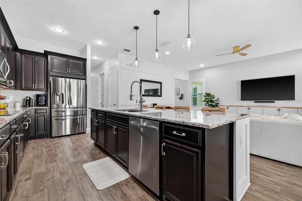 10522 Cardera Drive Riverview, FL 33578 - Photo 17 of 43 a kitchen with stainless steel appliances kitchen island granite countertop a sink and a refrigerator