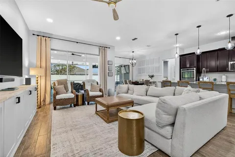 a living room with furniture kitchen view and a large window