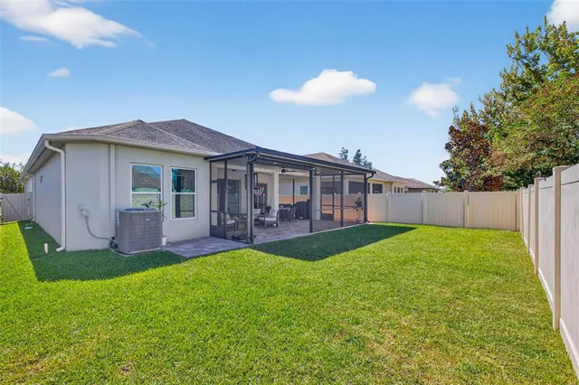 a view of a house with a backyard and a patio