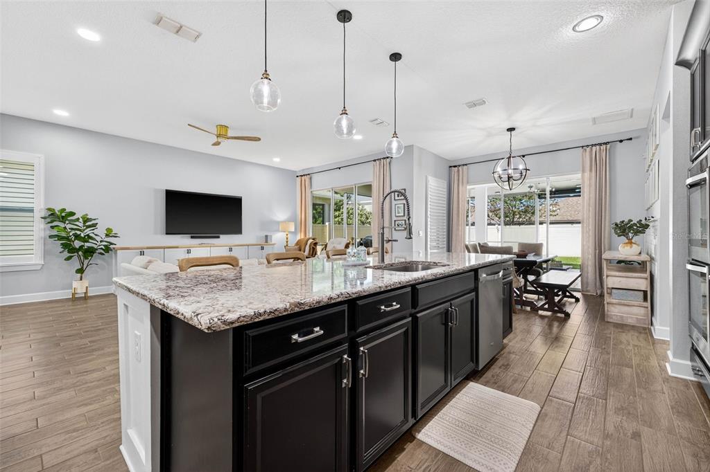 10522 Cardera Drive Riverview, FL 33578 - Photo 6 of 43 a kitchen with a center island wooden floor stainless steel appliances and a counter top space