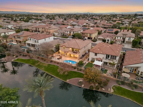 an aerial view of residential houses with outdoor space and lake view