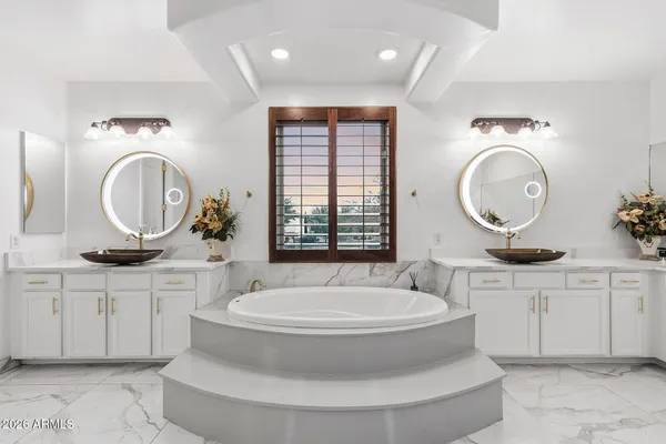 a large spacious bathroom with a double vanity sink a mirror and a bathtub