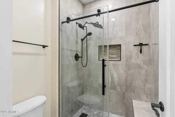 an empty room with wooden floor ceiling fan and windows