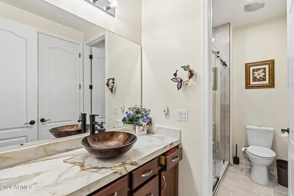 an empty room with wooden floor chandelier fan and windows