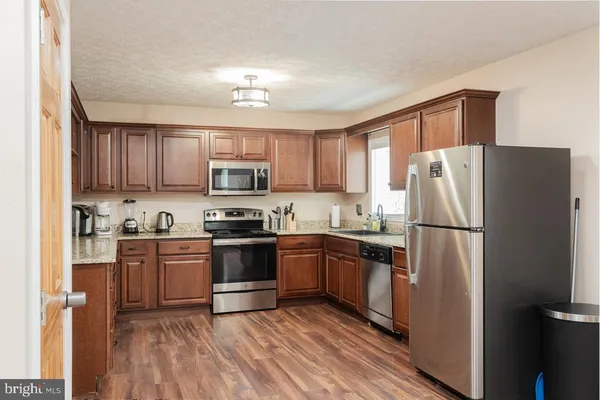 a kitchen with stainless steel appliances granite countertop a stove and a sink