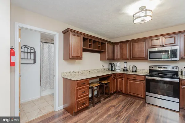 a kitchen with granite countertop stainless steel appliances sink and cabinets