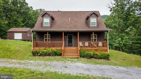 an aerial view of a house with a yard and trees all around