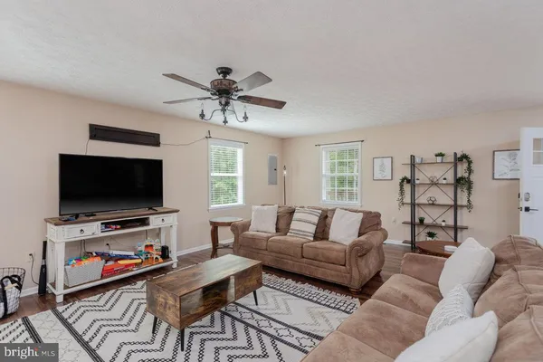 a dining room with furniture a chandelier and wooden floor