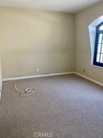 an empty room with mirror and entrance