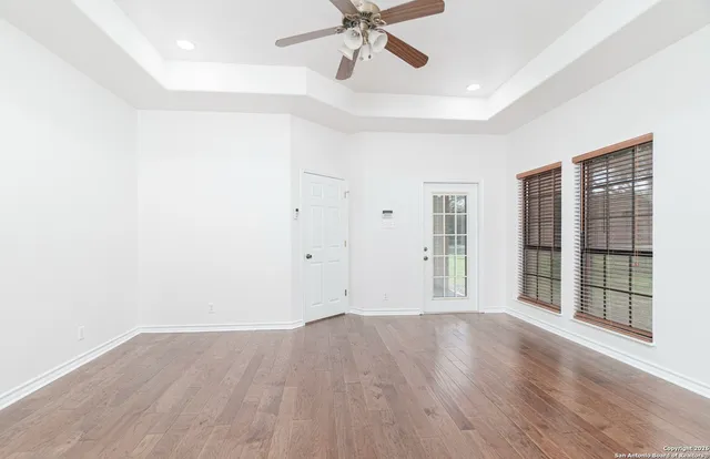 a view of a livingroom with wooden floor and a ceiling fan