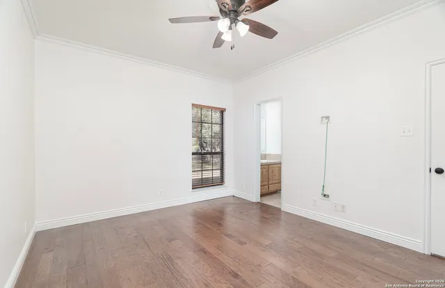 an empty room with windows and ceiling fan