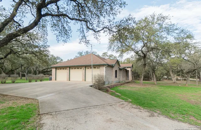 a front view of a house with a yard and trees