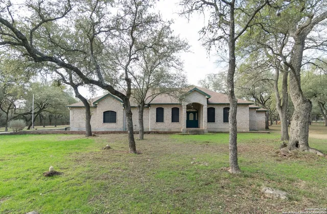 a front view of a house with a yard and trees