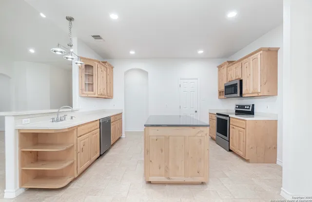 a large kitchen with stainless steel appliances granite countertop a sink and dishwasher a stove with wooden floor