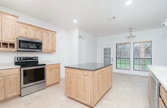 a kitchen with stainless steel appliances granite countertop a stove and a sink
