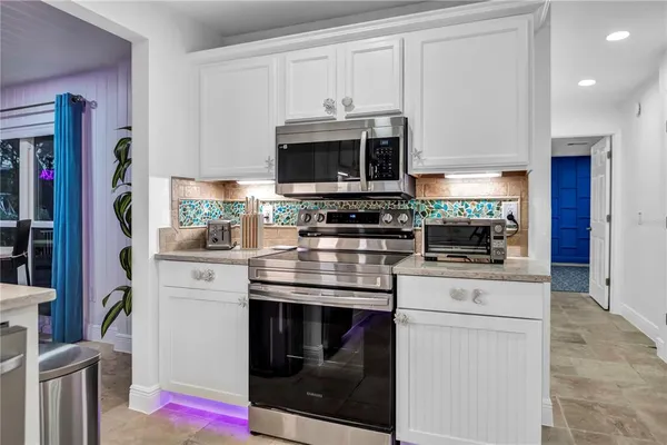 a kitchen with stainless steel appliances white cabinets and a stove