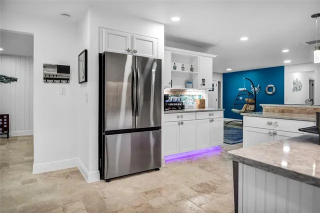 a kitchen with granite countertop a refrigerator and a sink