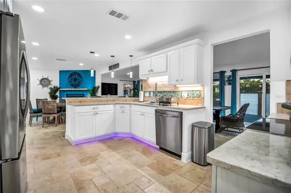 a kitchen with stainless steel appliances granite countertop a refrigerator sink and stove