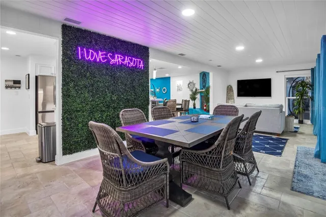 a dining room with furniture a rug and a floor to ceiling window