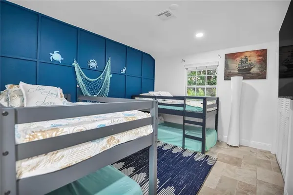 a bed room with a bed mirror and a lamp