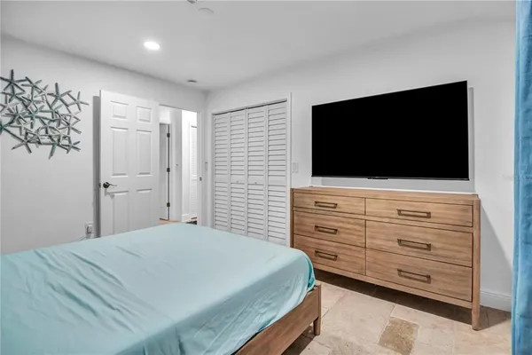 a bedroom with a bed and a flat screen tv