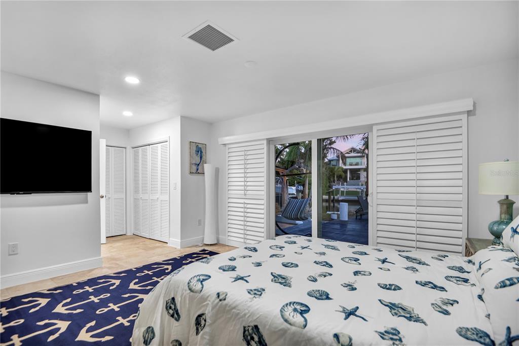 31 Lands End Lane Sarasota, FL 34242 - Photo 30 of 49 a bedroom with a bed and a flat screen tv