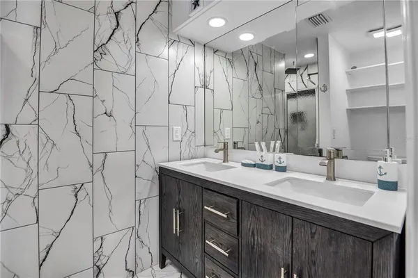 a bathroom with double vanity sink and a mirror