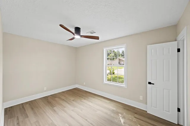wooden floor in an empty room with a window