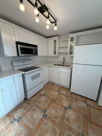 a kitchen with a sink a microwave and refrigerator