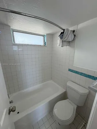 a white toilet sitting next to a bath tub and shower