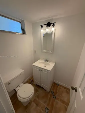 a bathroom with a toilet sink and mirror