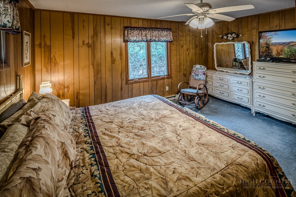 107-109 Shagbark Road Beech Mountain, NC 28604 - Photo 27 of 45 a bedroom with a bed a flat screen tv and dresser