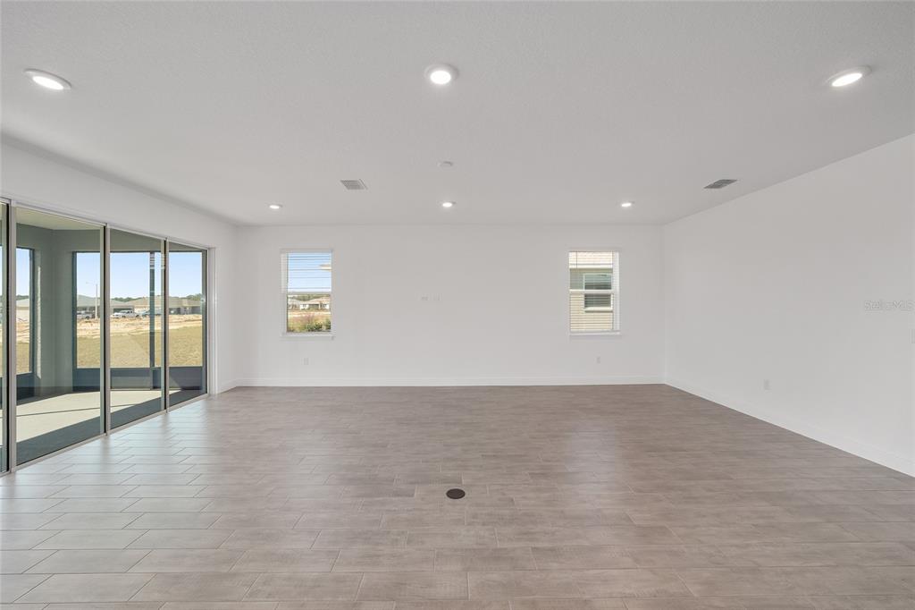 10104 Southwest 106th Circle Ocala, FL 34481 - Photo 12 of 47 an empty room with wooden floor and windows