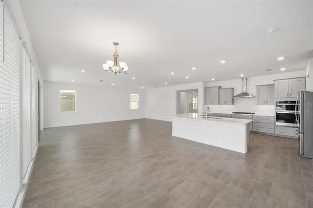 a view of kitchen with kitchen island sink refrigerator and white cabinets