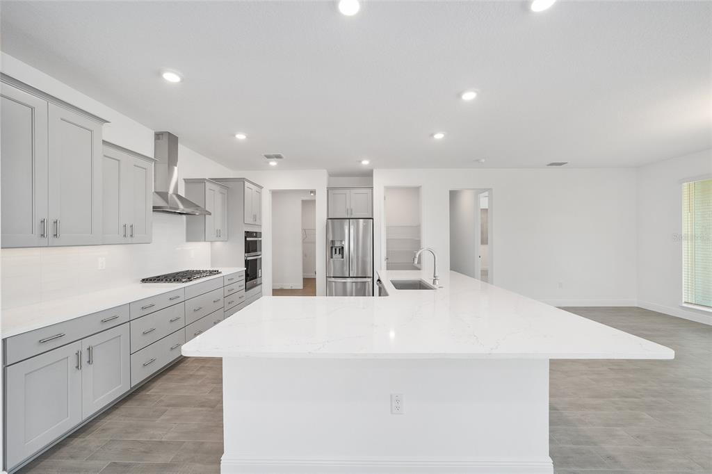 10104 Southwest 106th Circle Ocala, FL 34481 - Photo 20 of 47 a large white kitchen with kitchen island a sink a stove and refrigerator