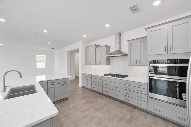 a large kitchen with stainless steel appliances granite countertop a stove a sink and a microwave