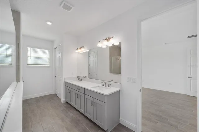 a bathroom with a double vanity sink and mirror