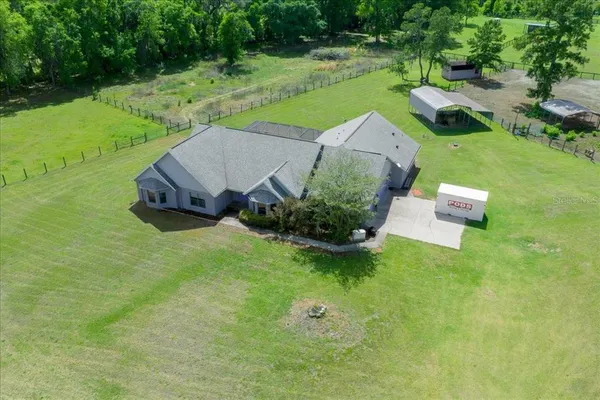 an aerial view of a house with a garden and trees