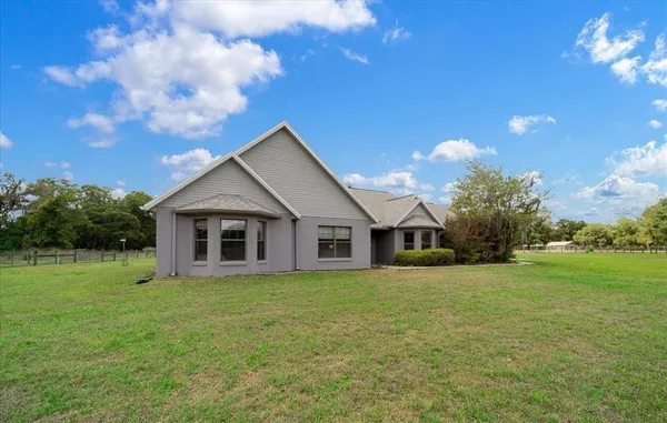a view of a house with backyard and porch